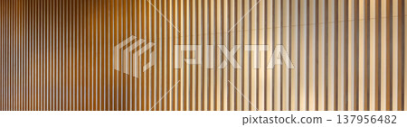 Vertical lines of wooden louvers and a gradient of light (abstract background) - an abstractly represented background material. Vertical lines of wooden louvers and a gradient of light (abstract background) - an abstractly represented background material. 137956482