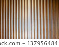 Vertical lines of wooden louvers and a gradient of light (abstract background) - an abstractly represented background material. 137956484