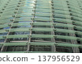 Reflections and geometric patterns on the glass facade (abstract urban background material) - an abstract capture of the exterior of glass architecture. 137956529