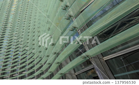 Reflections and geometric patterns on the glass facade (abstract urban background material) - an abstract capture of the exterior of glass architecture. 137956530