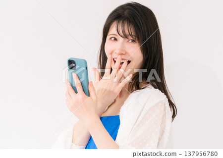 A woman with a smartphone is surprised. A woman with a smartphone is surprised. 137956780