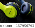 close up of lime green and black wireless headphones on dark background 137956793