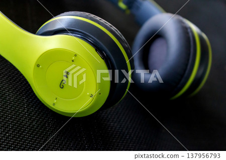close up of lime green and black wireless headphones on dark background 137956793