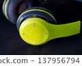 close up of lime green and black wireless headphones on dark background 137956794