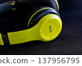 close up of lime green and black wireless headphones on dark background 137956795