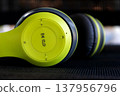 close up of lime green and black wireless headphones on dark background 137956796