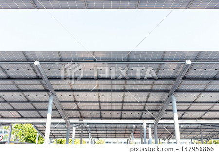 Aerial view of solar panels installed as shade canopy over parking lot with parked cars to generate electricity, photovoltaic technology Aerial view of solar panels installed as shade canopy over parking lot with parked cars to generate electricity, photovoltaic technology 137956866