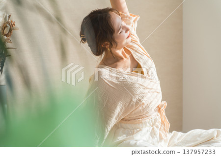 A woman doing yoga in the living room at home (relaxation, health care) A woman doing yoga in the living room at home (relaxation, health care) 137957233