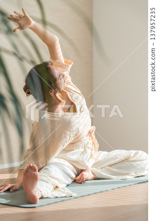 一位女士在家裡的客廳裡做瑜伽（放鬆，保健） 137957235
