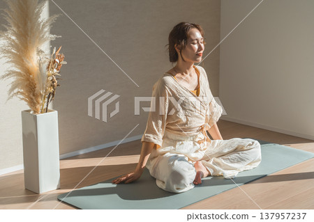一位女士在自家客廳做瑜珈（放鬆、保健、冥想） 137957237