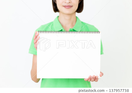 A middle-aged female care worker holding a sketchbook A middle-aged female care worker holding a sketchbook 137957738