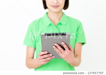 一位手持平板電腦的中年女性護理員。 一位手持平板電腦的中年女性護理員。 137957797