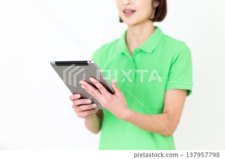 A middle-aged female care worker holding a tablet. 137957798