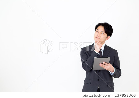 A middle-aged businessman struggling with a tablet. A middle-aged businessman struggling with a tablet. 137958306