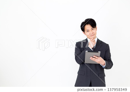 一位中年商人正在費力地使用平板電腦。 137958349