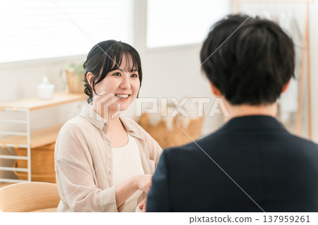 一位女士在上門推銷時,正在聽取推銷員的建議、解釋和介紹 一位女士在上門推銷時,正在聽取推銷員的建議、解釋和介紹 137959261