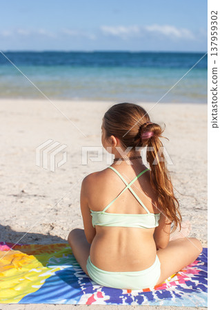 Teenager girl enjoying a sunny summer beach vacation in Tulum, Mexico, with white sand and beautiful turquoise ocean, finding peace and relaxation looking out at the calm sea Teenager girl enjoying a sunny summer beach vacation in Tulum, Mexico, with white sand and beautiful turquoise ocean, finding peace and relaxation looking out at the calm sea 137959302