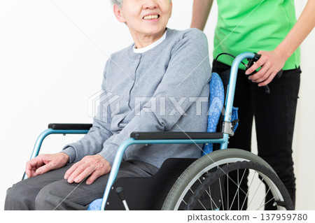 一名護理人員正在協助一位坐在輪椅上的老人。 一名護理人員正在協助一位坐在輪椅上的老人。 137959780