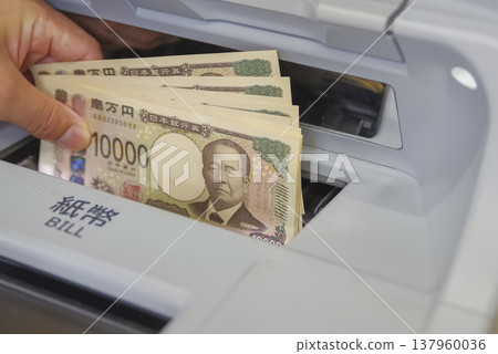 一名男子在自動櫃員機提款時雙手的照片 一名男子在自動櫃員機提款時雙手的照片 137960036