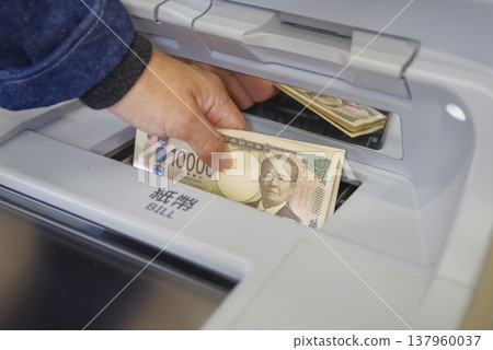 一名男子在自動櫃員機提款時雙手的照片 一名男子在自動櫃員機提款時雙手的照片 137960037
