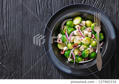 Mediterranean brussels sprouts salad with feta cheese, olives and red onion in black bowl Mediterranean brussels sprouts salad with feta cheese, olives and red onion in black bowl 137960338