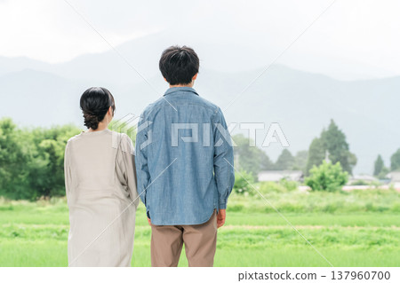 A young couple looking at the countryside scenery (immigration, land search) A young couple looking at the countryside scenery (immigration, land search) 137960700