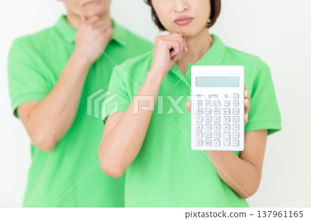 A middle-aged female care worker struggling with a calculator. 137961165