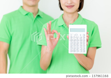 一位中年女護理員拿著計算器，做了一個畫圈的動作。 137961168