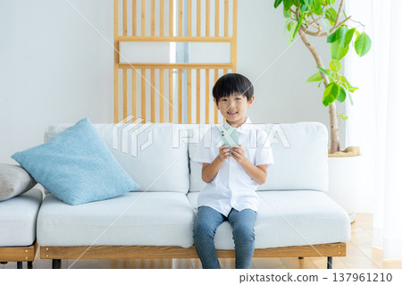 Elementary school boy using a smartphone 137961210