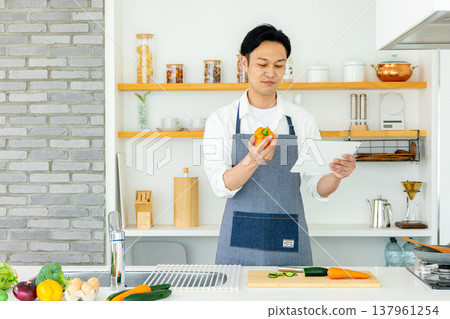 A man using a tablet in the kitchen 137961254