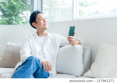 男人在沙發上使用智能手機 137961271