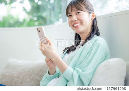 一位獨居女性使用智慧型手機 137961298