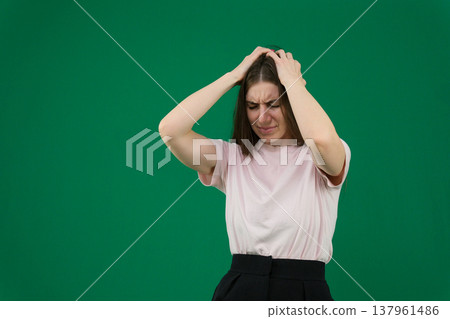 different emotions of a young girl on a green background chromakey beautiful facial features real people pink T-shirt white skinned European. black flared wide leg trousers 137961486