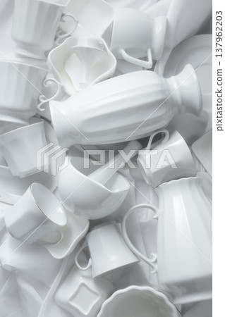 Various white ceramic kitchenware on white fabric. Various white ceramic kitchenware on white fabric. 137962203