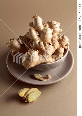 Ginger root on a beige background. Ginger root on a beige background. 137962233
