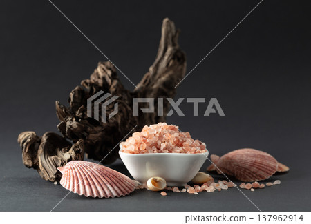 Pink himalayan salt with snags and seashells on a black background. Pink himalayan salt with snags and seashells on a black background. 137962914