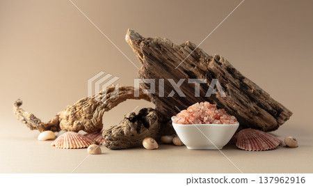 Pink himalayan salt with snags and seashells on a beige background. Pink himalayan salt with snags and seashells on a beige background. 137962916