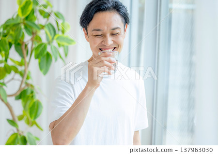 一名男子手拿一杯水 137963030