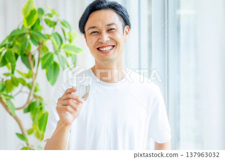 A man holding a glass of water 137963032