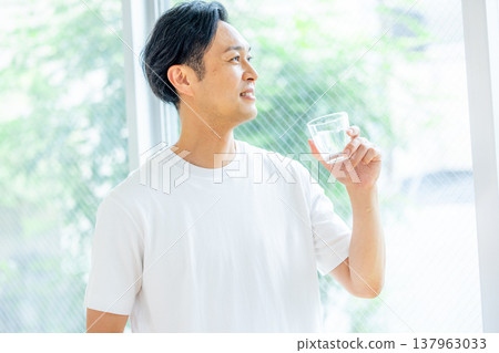 A man holding a glass of water A man holding a glass of water 137963033