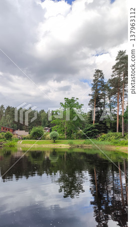 A scenic spring landscape features water and fresh greenery. Harmony and natural beauty. 137963112