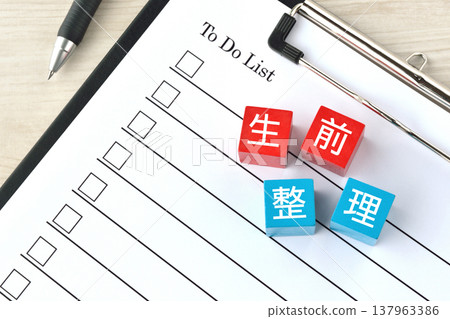 一塊木塊，上面寫著「身後事安排」字樣，旁邊還有一張清單。 137963386
