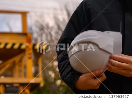 Hands holding a work helmet Hands holding a work helmet 137963437