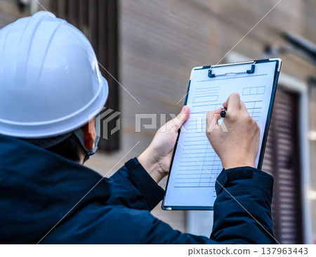 Worker fills out record Worker fills out record 137963443