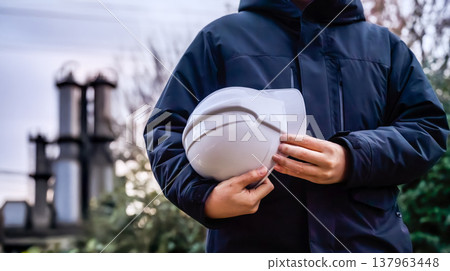 工人手裡拿著一個安全帽。 137963448