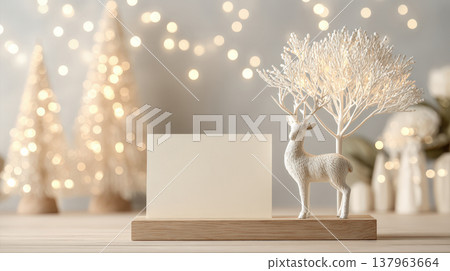 Minimalist holiday scene featuring a white paper card on a wooden base next to a deer statue. Soft bokeh lights and golden tones create a sophisticated winter atmosphere for card presentations Minimalist holiday scene featuring a white paper card on a wooden base next to a deer statue. Soft bokeh lights and golden tones create a sophisticated winter atmosphere for card presentations 137963664