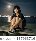 A high school girl sitting in a park at night 137963716