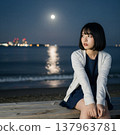 A woman sitting by the beach 137963781