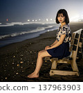 A woman sitting on the beach at sunset 137963903