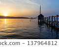 A view of Lake Togo and the setting sun, with a hut for observing the four-pronged net fishing method floating at the end of the pier. 137964812